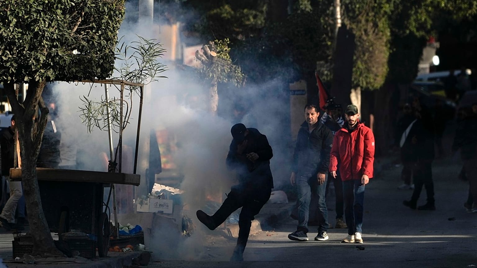 شبان فلسطينيون يشتبكون مع قوات الأمن خارج مخيم جنين للاجئين في الضفة الغربية، الاثنين 16 ديسمبر/كانون الأول 2024.