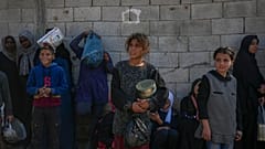أطفال فلسطينيون ينتظرون الحصول على الطعام في مركز توزيع في دير البلح، قطاع غزة، الثلاثاء، 17 ديسمبر، 2024.