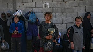 أطفال فلسطينيون ينتظرون الحصول على الطعام في مركز توزيع في دير البلح، قطاع غزة، الثلاثاء، 17 ديسمبر، 2024.