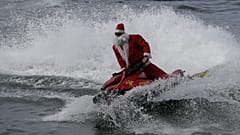 Un pompier déguisé en Père Noël conduit un jet ski sur la plage de Copacabana à Rio de Janeiro, le 17.12.2024