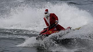 Un bombero vestido de Papá Noel conduce una moto acuática en la playa de Copacabana en Río de Janeiro, 17.12.2024
