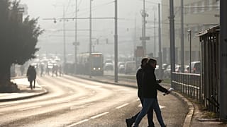 Des personnes traversent la rue dans un brouillard de pollution, alors que le smog recouvre Sarajevo, en Bosnie, en décembre 2024.
