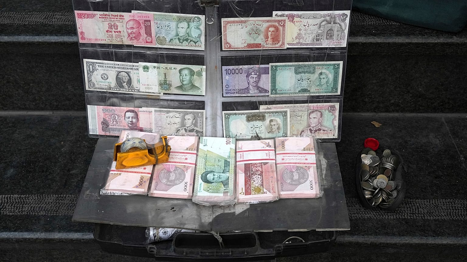Zdjęcie aktualnych i przedrewolucyjnych irańskich banknotów i walut obcych prezentowane przez sprzedawcę w handlowej dzielnicy Teheranu.