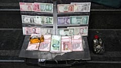 File picture of current and pre-revolution Iranian banknotes and foreign currencies are displayed by a vendor in the commercial district of Tehran