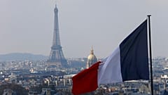 Eyfel Kulesi, Invalides Kubbesi ve çatıların bulunduğu Fransız başkentinin silueti üzerindeki Fransız bayrağı, Paris'teki Pantheon Kubbesi'nin sütunundan görülüyor.