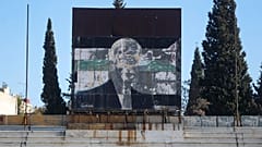 Une affiche endommagée du défunt président syrien Hafez al-Assad est vue au-dessus des tribunes d'un stade utilisé comme poste militaire à Damas, le 19 décembre 2024.