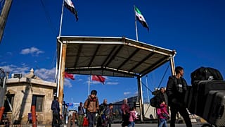 سوريون يعبرون الحدود من تركيا إلى سوريا عند بوابة معبر باب السلامة، سوريا، الجمعة، 13 ديسمبر/كانون الأول 2024