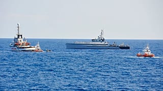 الشرطة المالية الإيطالية وقوارب خفر السواحل تحيط بسفينة الإنقاذ الإنسانية الإسبانية "أوبن آرمز" بعد أن قفز مهاجرون في الماء، الثلاثاء 20 أغسطس/آب 2019.