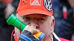 A striking VW employee An employee blows into a horn during a warning strike by the union IG Metall, in front of the car maker's HQ in Wolfsburg