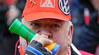 A striking VW employee An employee blows into a horn during a warning strike by the union IG Metall, in front of the car maker's HQ in Wolfsburg