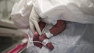 2020 yılında çekilmiş bu fotoğrafta bir sağlık çalışanının prematüre bebeğe sarıldığı görülüyor.