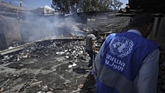 Bir UNRWA çalışanı İsrail bombardımanında yıkılan bir okulun enkazını inceliyor.