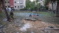 جندي إسرائيلي يراقب الموقع الذي سقط فيه الصاروخ الذي أطلق من اليمن في منطقة يافا، في تل أبيب، إسرائيل، السبت 21 ديسمبر 2024