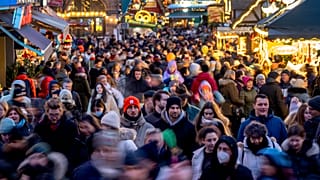 أشخاص يسيرون في شارع صغير بين سوق عيد الميلاد وشارع التسوق الرئيسي في فرانكفورت، ألمانيا، السبت 10 ديسمبر/كانون الأول 2022