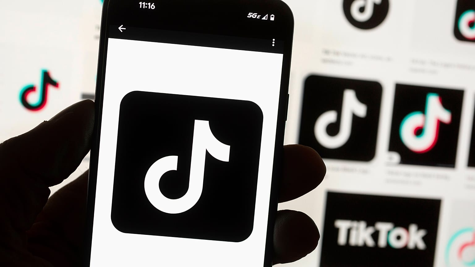 El logotipo de TikTok se muestra en un teléfono móvil frente a la pantalla de un ordenador en Boston, 14 de octubre de 2022.