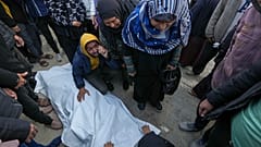 Familiares y vecinos lloran el cuerpo de una de las víctimas de un ataque israelí a una casa el sábado por la noche mientras se preparan para un funeral