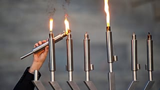 Haham Akiva Hall, Mississippi Eyalet Meclisi'nde Hanuka'nın yedinci gecesi Gulfport'taki Beth Israel Cemaati'nin töreni sırasında menorayı yakıyor, 13 Aralık 2023