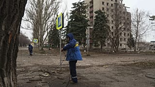 Trabalhadores municipais verificam os cabos elétricos após um bombardeamento russo no centro de Pokrovsk, 21 de dezembro de 2024