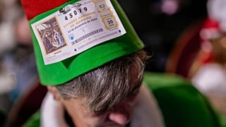 Um espetador aguarda o início do sorteio anual da lotaria de Natal em Madrid, 22 de dezembro de 2024