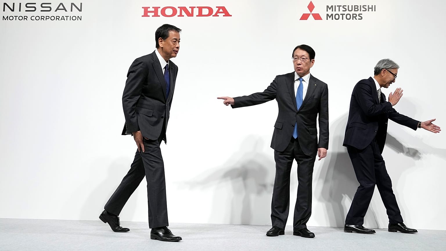 Nissan Chief Executive Makoto Uchida, left, Takao Kato, CEO of Mitsubishi Motors, centre, and Honda Chief Executive Toshihiro Mibe, leave after a news conference in Tokyo