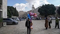 فتى يبيع البالونات خارج كنيسة المهد قبل عيد الميلاد في مدينة بيت لحم بالضفة الغربية 21 كانون الأول ديسمبر 2024