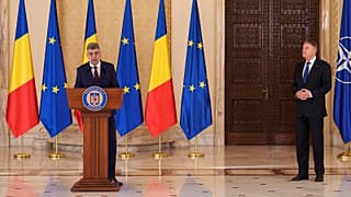 Başbakan adayı Marcel Ciolacu, solda, Romanya Cumhurbaşkanı Klaus Iohannis'in (sağda) kendisini Bükreş'te yeni hükümeti kurmakla görevlendirmesinin ardından konuşuyor, 23 Aralık 2024
