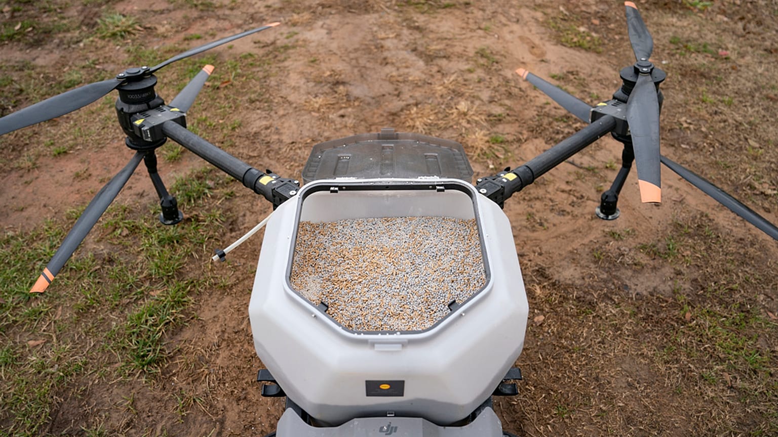 راسل هيدريك يستعد لتشغيل طائرة درون من طراز DJI لنشر غطاء المحاصيل في مزرعته.