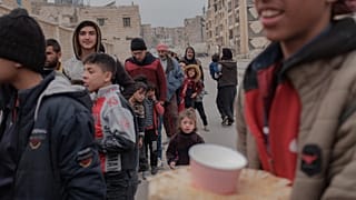 Sirios esperan para recibir alimentos en Alepo