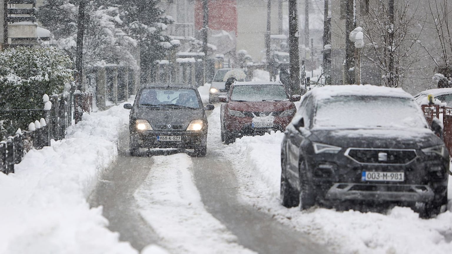 Um carro circula na rua durante uma forte queda de neve em Bihac, na Bósnia.