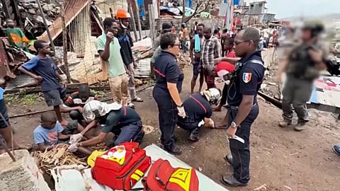 Des médecins s'occupent d'enfants pendant que les pompiers et les forces de sécurité mènent des opérations de recherche et de sauvetage.