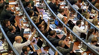 FILE: Kosovo lawmakers vote during the parliament session in Pristina, 7 July 2021