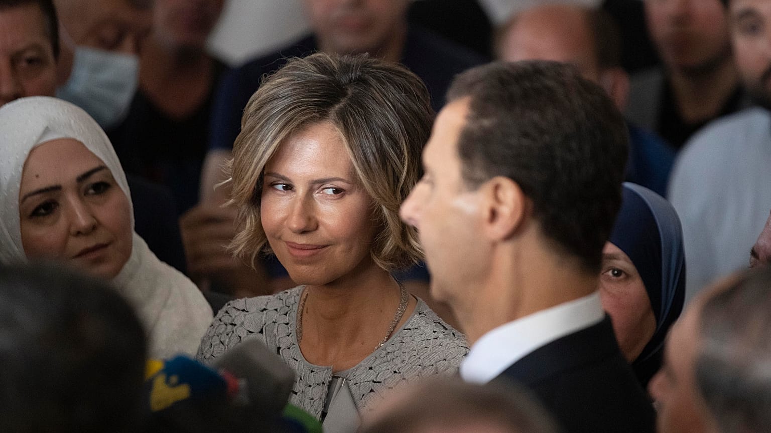 FOTO DE ARQUIVO - A primeira-dama da Síria, Asma Assad, à esquerda, ouve o seu marido, o Presidente sírio Bashar Assad, enquanto este fala aos meios de comunicação social em Douma, na Síria, a 26 de maio de 2021.