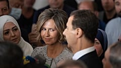  أسماء الأسد، إلى اليسار، تستمع إلى زوجها الرئيس السوري بشار الأسد وهو يتحدث إلى وسائل الإعلام في دوما، سوريا، 26 مايو/أيار 2021.