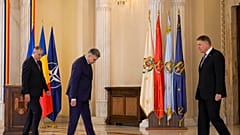 Ο πρωθυπουργός της Ρουμανίας Marcel Ciolacu και ο πρόεδρος της Ρουμανίας Klaus Iohannis αναζητούν τις θέσεις που έχουν ορίσει για μια οικογενειακή φωτογραφία μετά την τελετή ορκωμοσίας.