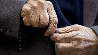 صورة لمسن يمسك مسبحة 