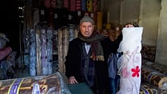 صاحب محل أقمشة في السوق القديم، داخل متجره في مدينة حلب القديمة، سوريا. يوم الأحد، 21 يناير/كانون الثاني 2018