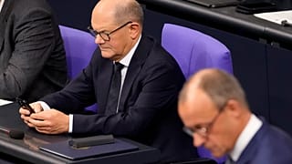 Le chancelier sortant Olaf Scholz consulte son téléphone au parlement allemand.