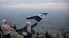 جوانان سوری با پرچم جدید سوریه بر فراز بلندی های دمشق