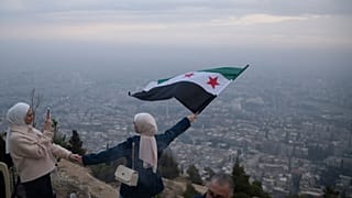جوانان سوری با پرچم جدید سوریه بر فراز بلندی های دمشق