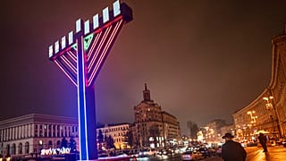 Мужчина проходит мимо меноры после зажжения свечей в пятую ночь еврейского праздника Ханука на площади Независимости в Киеве, Украина, понедельник, 11 декабря 2023 года.