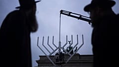 Jehuda Teichtal és Shmuel Segal rabbik nézik, ahogy a Chábád Oktatási Központ felállít egy óriási menórát a berlini Brandenburgi kapunál, - 2024. december 23.