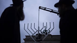 Jehuda Teichtal és Shmuel Segal rabbik nézik, ahogy a Chábád Oktatási Központ felállít egy óriási menórát a berlini Brandenburgi kapunál, - 2024. december 23.
