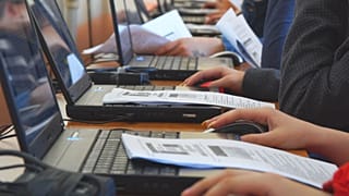 Varios alumnos trabajan con ordenadores en clase.