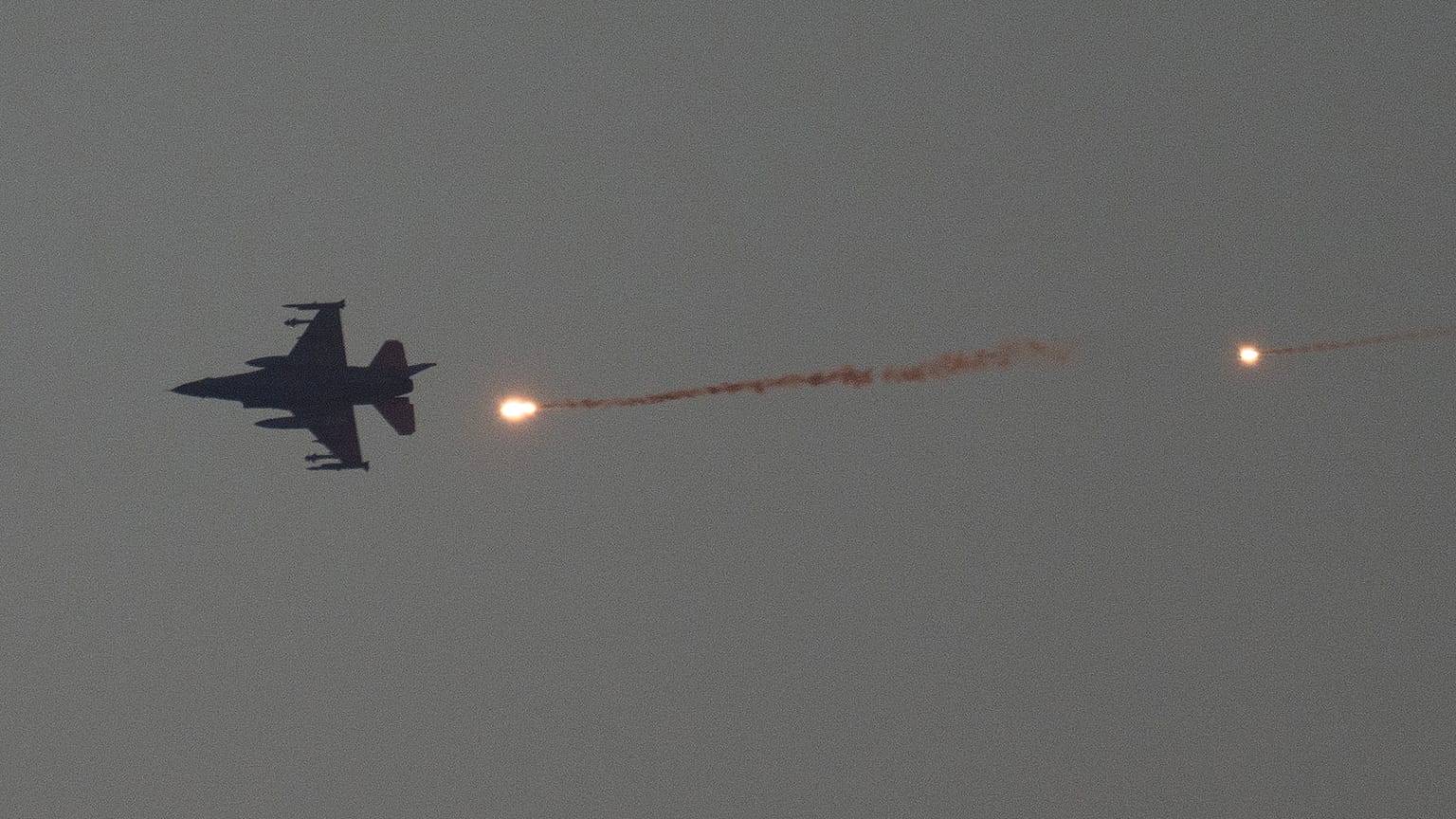 Un avion de chasse israélien lance des fusées éclairantes alors qu'il survole la bande de Gaza, vue depuis le sud d'Israël, le 16 janvier 2024.