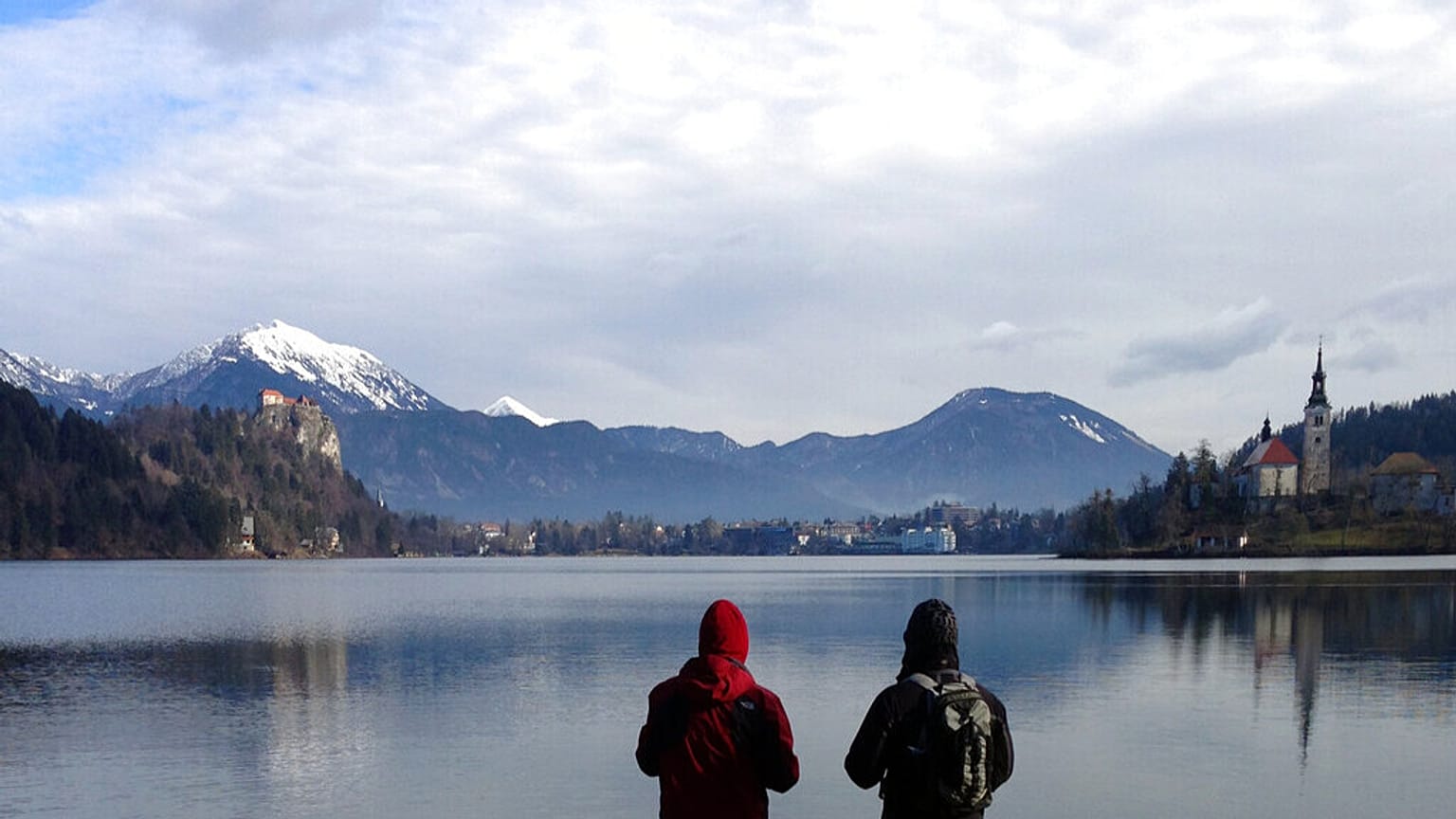  In this photo taken Tuesday, Jan. 27, 2015, people stand by the Lake Bled in Slovenia with a island and the Church of Our Lady on it.