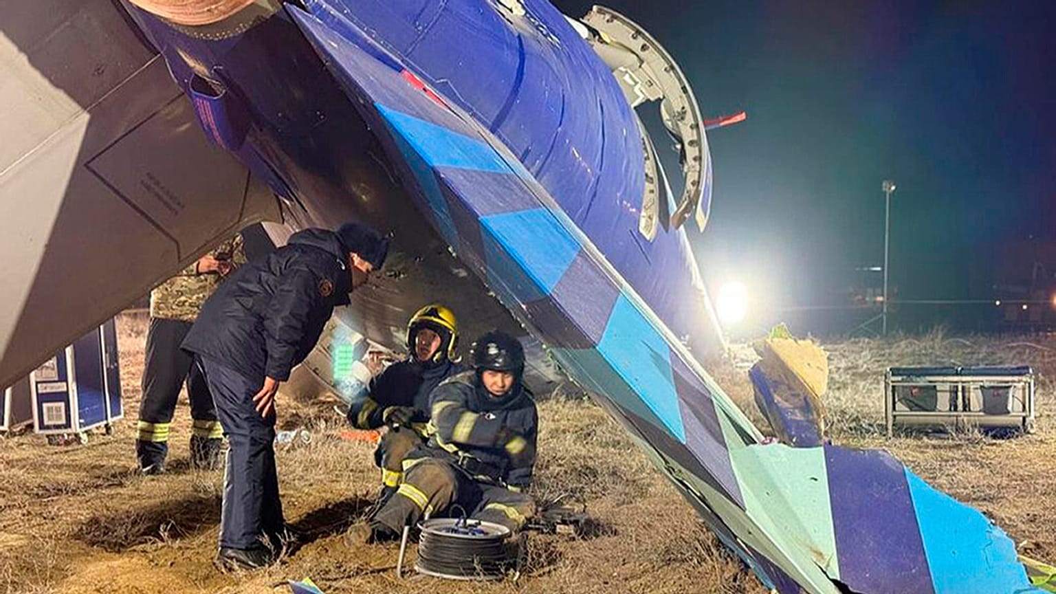 Kazakistan Acil Durum Bakanlığı Basın Servisi tarafından yayınlanan bu fotoğrafta, kurtarma ekipleri havaalanı yakınlarında yerde yatan Azerbaycan Havayolları'na ait Embraer 190'ın enkazında çalışıyor.
