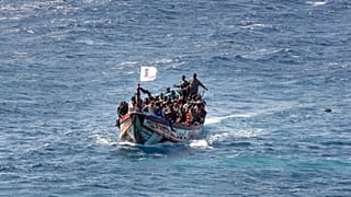 Os migrantes enchem um barco de madeira enquanto navegam para o porto de La Restinga, na ilha canária de El Hierro, em Espanha, a 18 de agosto de 2024.