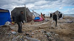 فلسطينيون ينصبون خيمة في مخيم للنازحين على شاطئ البحر في دير البلح بقطاع غزة، الثلاثاء 26 نوفمبر/تشرين الثاني 2024