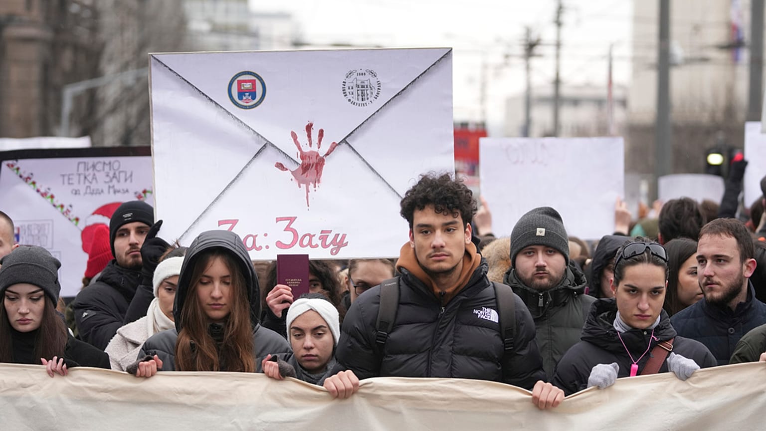 Des personnes bloquent la circulation en silence pendant une manifestation devant le bâtiment du gouvernement à Belgrade, Serbie, mercredi 25 décembre 2024.