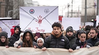Des personnes bloquent la circulation en silence pendant une manifestation devant le bâtiment du gouvernement à Belgrade, Serbie, mercredi 25 décembre 2024.